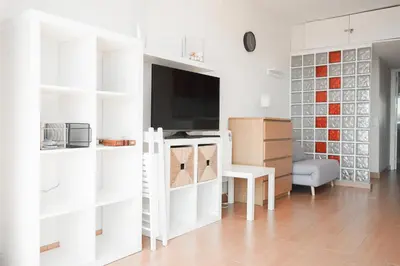 a living room with white shelves and a tv at Loft Ponent, Sant Pol de Mar in San Pol de Mar