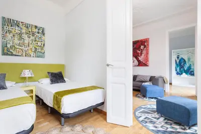 a bedroom with two beds and a living room at Art House Station Rocafort ´Sant Antoni´ in Barcelona