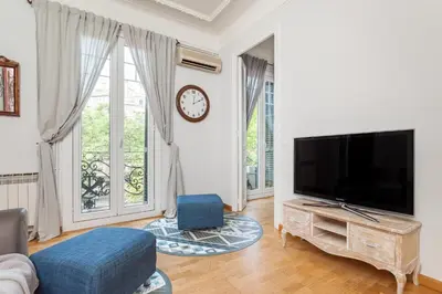 a living room with a flat screen tv and a large window at Art House Station Rocafort ´Sant Antoni´ in Barcelona