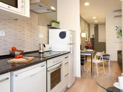 a kitchen with a white refrigerator and a table at Sagrada Familia in Barcelona