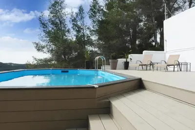 a swimming pool with a deck and a patio with chairs at TERRAVU in Sant Pere de Ribes