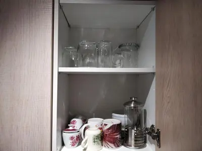 a cupboard filled with glass jars and other items at Bonavista Bright Sea View Studio with Balcony in Calella