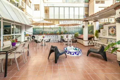 a patio with tables and chairs and umbrellas at Fabrizzios Terrace Hostel in Barcelona