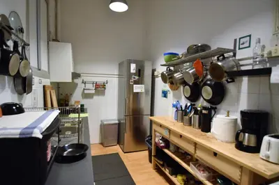 a kitchen with a refrigerator and a counter with pots and pans at Fabrizzios Terrace Hostel in Barcelona