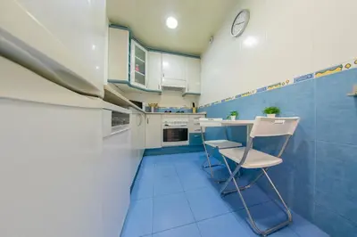 a blue and white kitchen with a table and a chair at Ahllenrock Cornellà - Parking Gratis- Cerca BCN in Cornellà de Llobregat