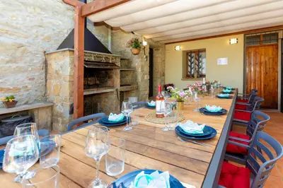 a long wooden table with chairs and wine glasses at 8 to 10 Sleeps Private Pool Villa & BBQ Near Barcelona in Rocafort