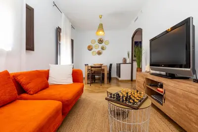 a living room with a orange couch and a television at 8 to 10 Sleeps Private Pool Villa & BBQ Near Barcelona in Rocafort