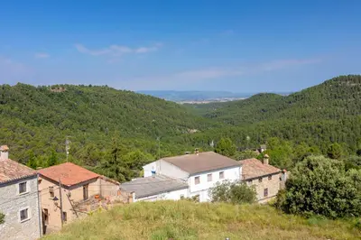 a group of buildings on a hill with mountains in the background at 8 to 10 Sleeps Private Pool Villa & BBQ Near Barcelona in Rocafort
