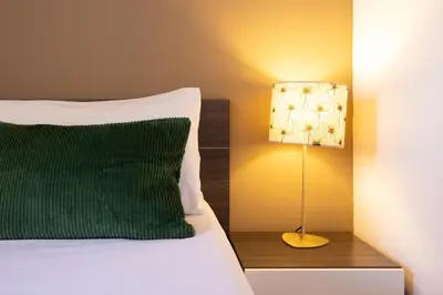 a bed with a green pillow and a lamp at Stay U-nique Apartments Radas in Barcelona