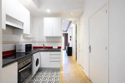 a kitchen with white cabinets and a yellow tile floor at Stay U-nique Apartments Radas in Barcelona