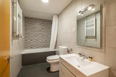 a bathroom with a sink and a toilet and a mirror at Stay U-nique Apartments Aribau in Barcelona