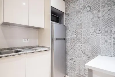 a kitchen with white cabinets and a refrigerator at Spacious 3 bed Apt in the heart of Sant Antoni, Barcelona in Barcelona