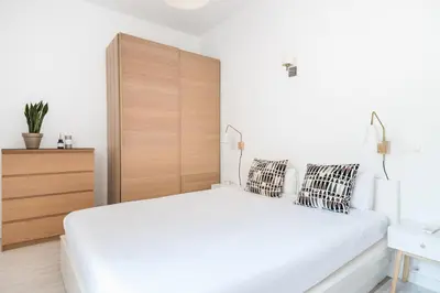 a bedroom with a white bed and a wooden headboard at Spacious 3 bed Apt in the heart of Sant Antoni, Barcelona in Barcelona
