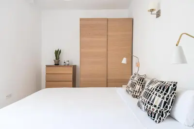 a bedroom with a white bed and a wooden headboard at Spacious 3 bed Apt in the heart of Sant Antoni, Barcelona in Barcelona