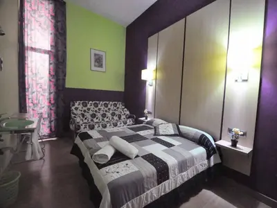 a bedroom with a bed and a green wall at BARCELONA GOTIC Guesthouse in Barcelona