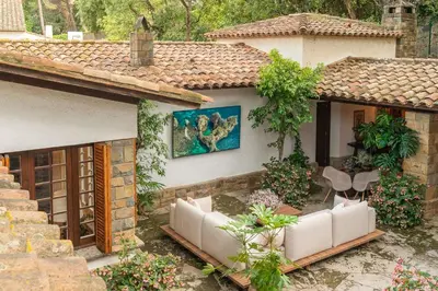 a house with a patio with white couches and a painting at Villa Can Duarry - Barcelona Country House 1 in Premia de Dalt