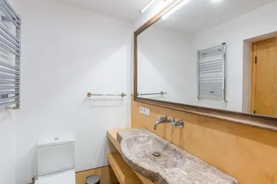 a bathroom with a stone sink and a mirror at Villa Can Duarry - Barcelona Country House 1 in Premia de Dalt