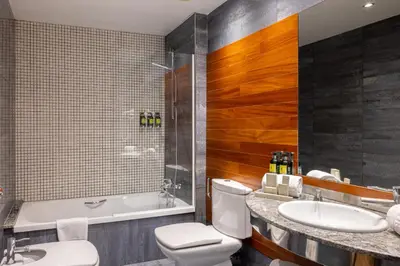 a bathroom with a toilet and a sink and a tub at Hotel Sansi Barcelona in Barcelona