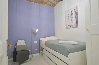 a bedroom with a bed and a purple wall at Apartamento Alejandro en BCN in Barcelona