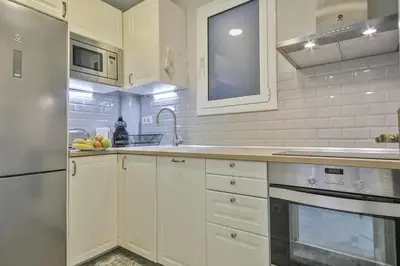 a kitchen with white cabinets and a stainless steel refrigerator at Apartamento Alejandro en BCN in Barcelona