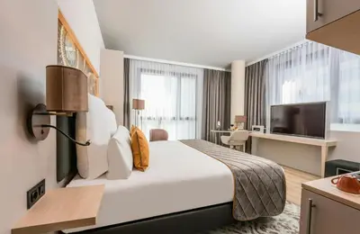 a hotel room with a large bed and a tv at Leonardo Royal Hotel Barcelona Fira in Barcelona
