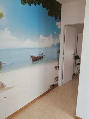 a wall mural of a boat on the beach at Apartamento duplex vacacional in Arenys de Mar