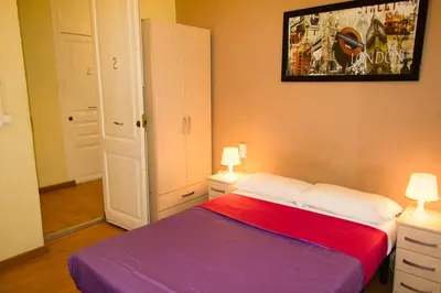 a bedroom with a bed and two lamps and a painting at Hostal MiMi Las Ramblas in Barcelona