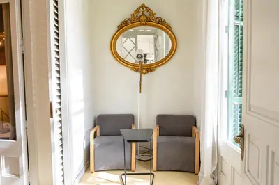 two chairs and a table in a hallway with a mirror at B&B Boutique Ca La Maria in Barcelona