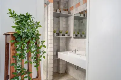 a bathroom with a sink and a potted plant at Angel Views Penthouse by Hello Homes Sitges in Sitges