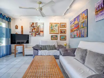 a living room with a couch and a tv at Angel Views Penthouse by Hello Homes Sitges in Sitges