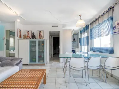 a living room with a blue table and chairs at Angel Views Penthouse by Hello Homes Sitges in Sitges
