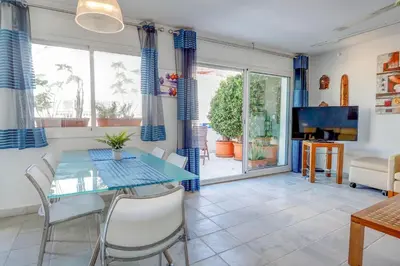a dining room with a glass table and chairs at Angel Views Penthouse by Hello Homes Sitges in Sitges