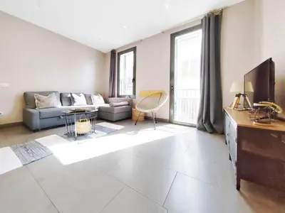 a living room with a couch and a tv at Bo&Co Apartments in Sitges