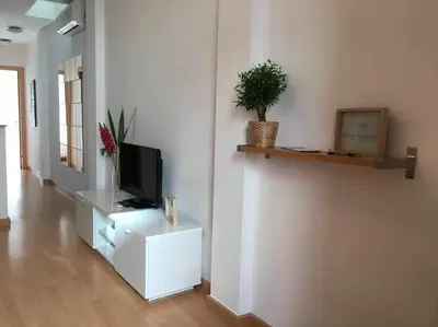 a living room with a television on a white cabinet at Pretty Apartament in Barcelona