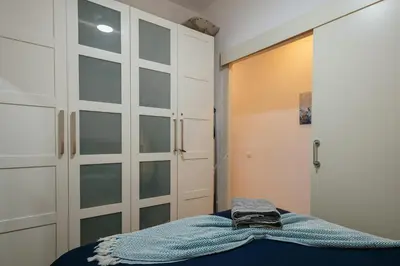 a room with a closet and a door with a shirt on a bed at Cute Apartment in Barcelona