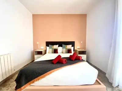 a bedroom with a large bed with red pillows at Duplex oasis in Sitges