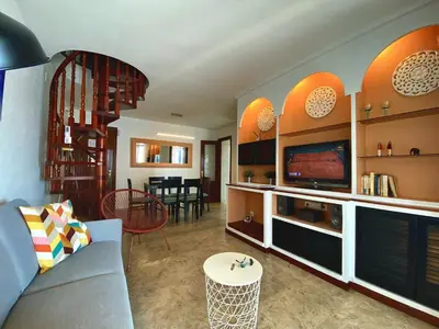 a living room with a blue couch and a tv at Duplex oasis in Sitges