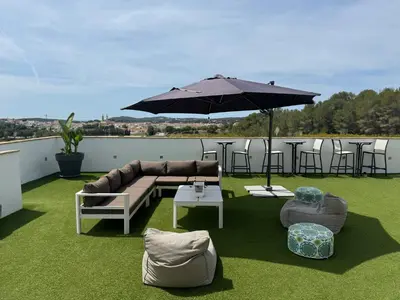 a patio with a couch and an umbrella and chairs at Villa Masia Capdet in Sant Pere de Ribes
