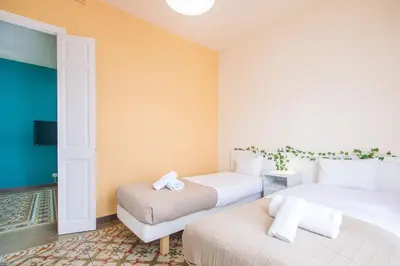 a room with two beds and a couch in it at Be barcelona arco del triunfo sunny colors 2 in Barcelona