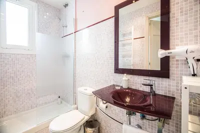 a bathroom with a sink and a toilet and a mirror at Be barcelona arco del triunfo sunny colors 2 in Barcelona