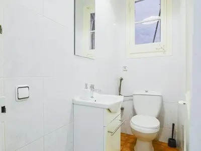 a white bathroom with a toilet and a sink at Be barcelona arco del triunfo sunny colors in Barcelona