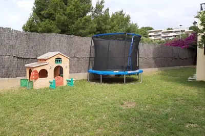 a trampoline in a yard with a dog house at Edard's Private Villa in Castelldefels