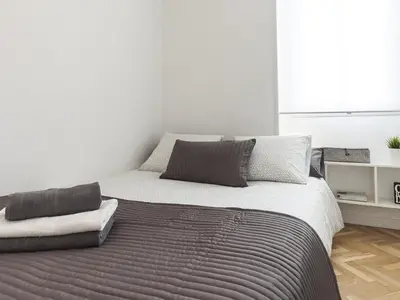 a white bedroom with a large bed with two pillows at Lets holidays apartment in Sant Martí in Barcelona