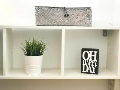 a shelf with two potted plants and a happy day sign at Lets holidays apartment in Sant Martí in Barcelona