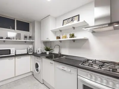 a white kitchen with a sink and a stove at Lets holidays apartment in Sant Martí in Barcelona