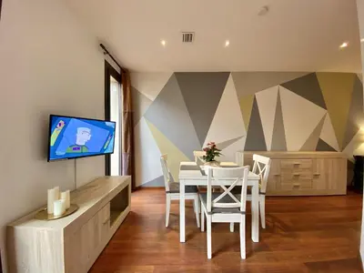 a dining room with a table and a tv on a wall at Sagrada familia apartment in Barcelona