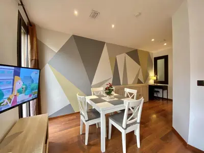 a dining room with a white table and chairs and a tv at Sagrada familia apartment in Barcelona