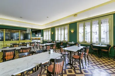 a restaurant with tables and chairs and windows at Hotel Robert in La Pobla de Claramunt