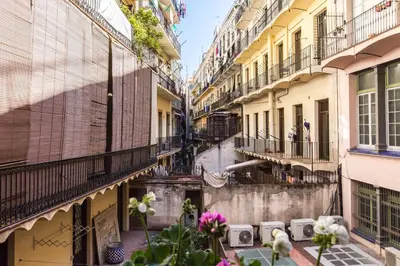 an alley in a city with buildings and flowers at El Born Guest House by Casa Consell in Barcelona