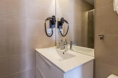 a bathroom with a sink and a mirror at El Born Guest House by Casa Consell in Barcelona